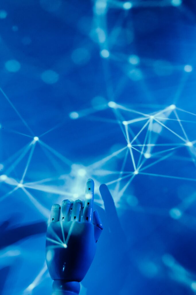 Main robotique touchant un réseau digital sur fond bleu — intelligence artificielle en entreprise