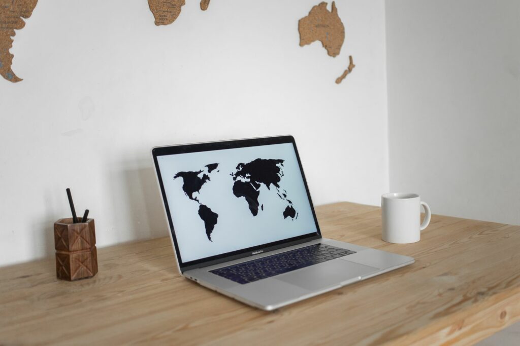 Ordinateur portable affichant une carte du monde, symbole d’un site multilingue tourné vers l’international