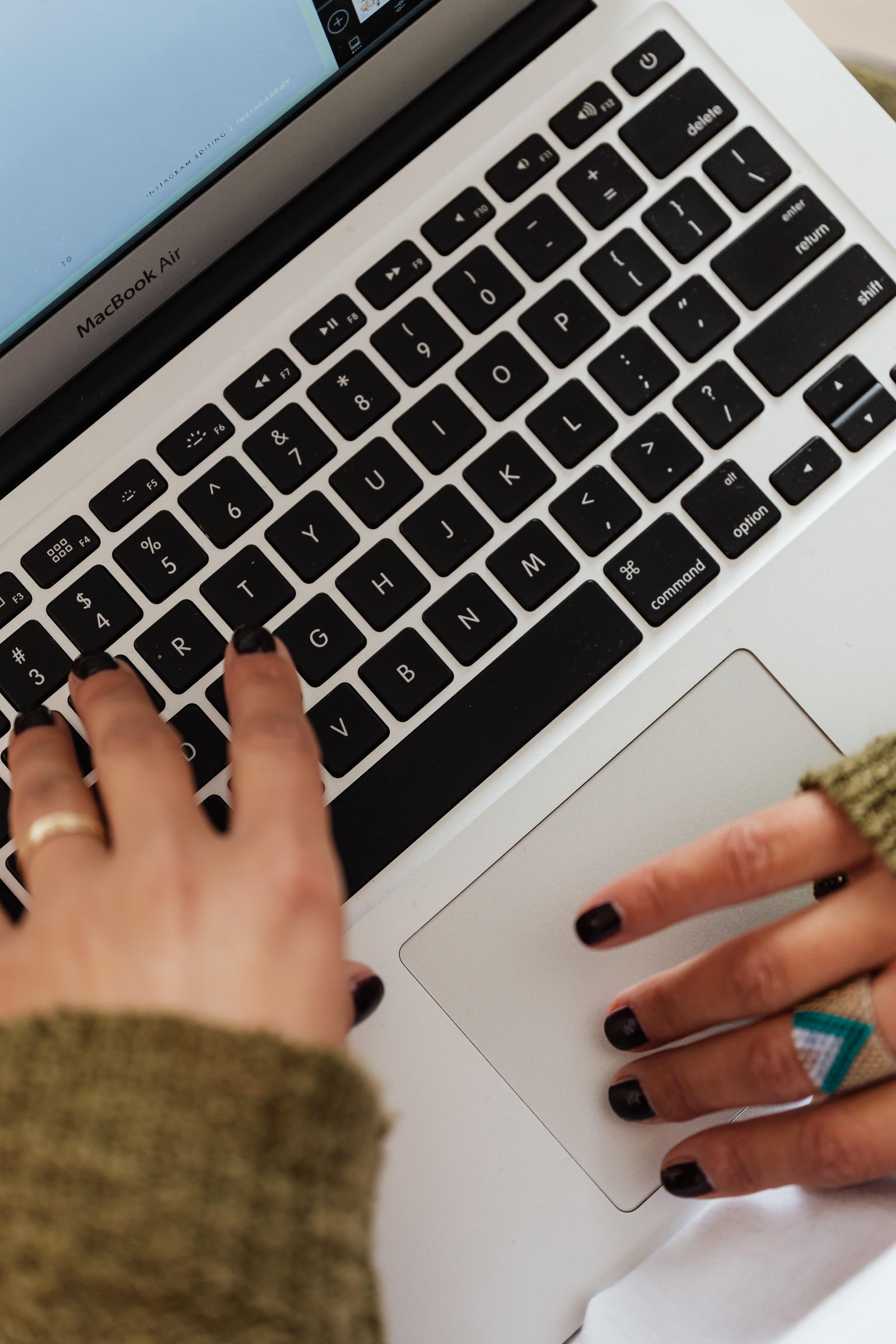 Mains tapant sur le clavier d’un ordinateur portable pour rédiger un prompt
